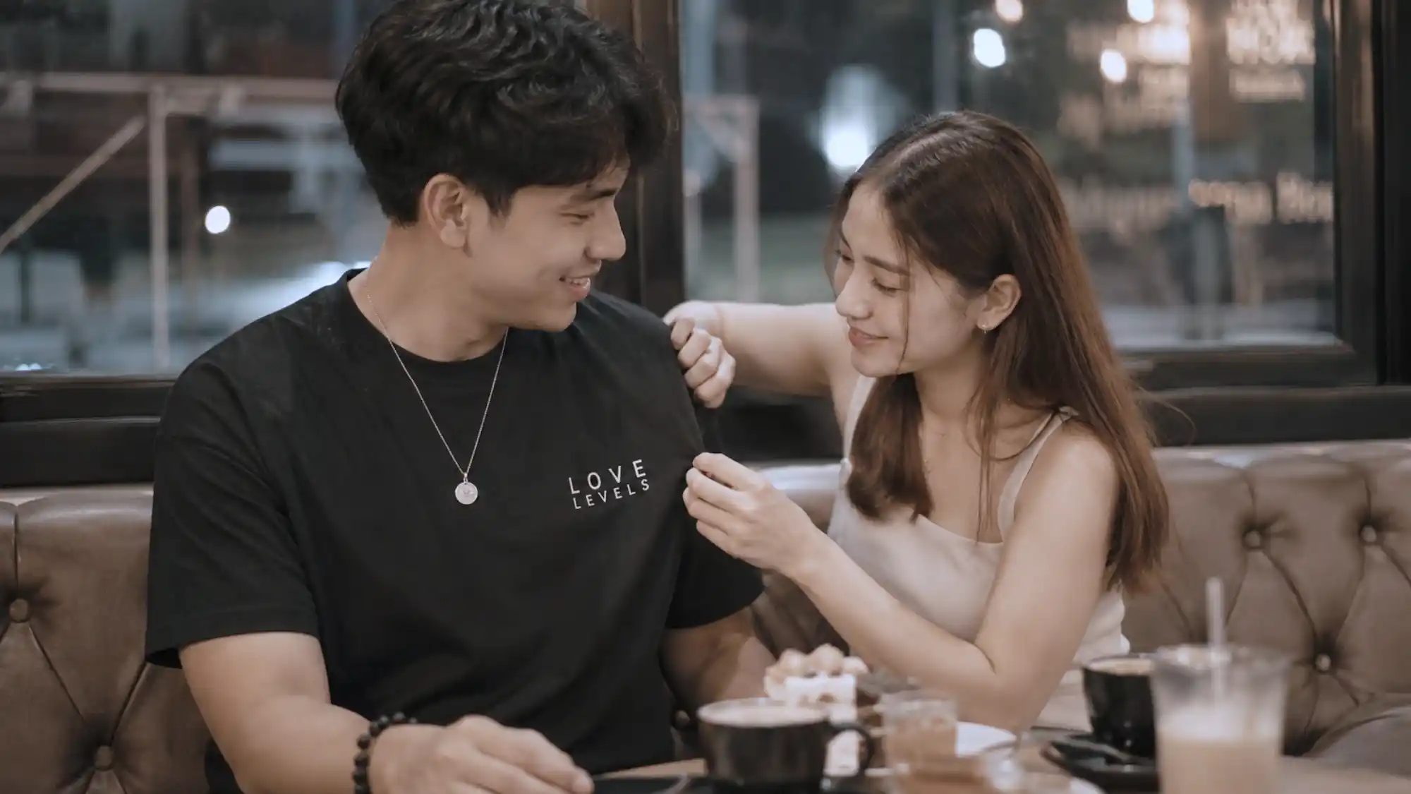 Filipino couple wearing QR code relationship shirts during a cozy cafe date_wp