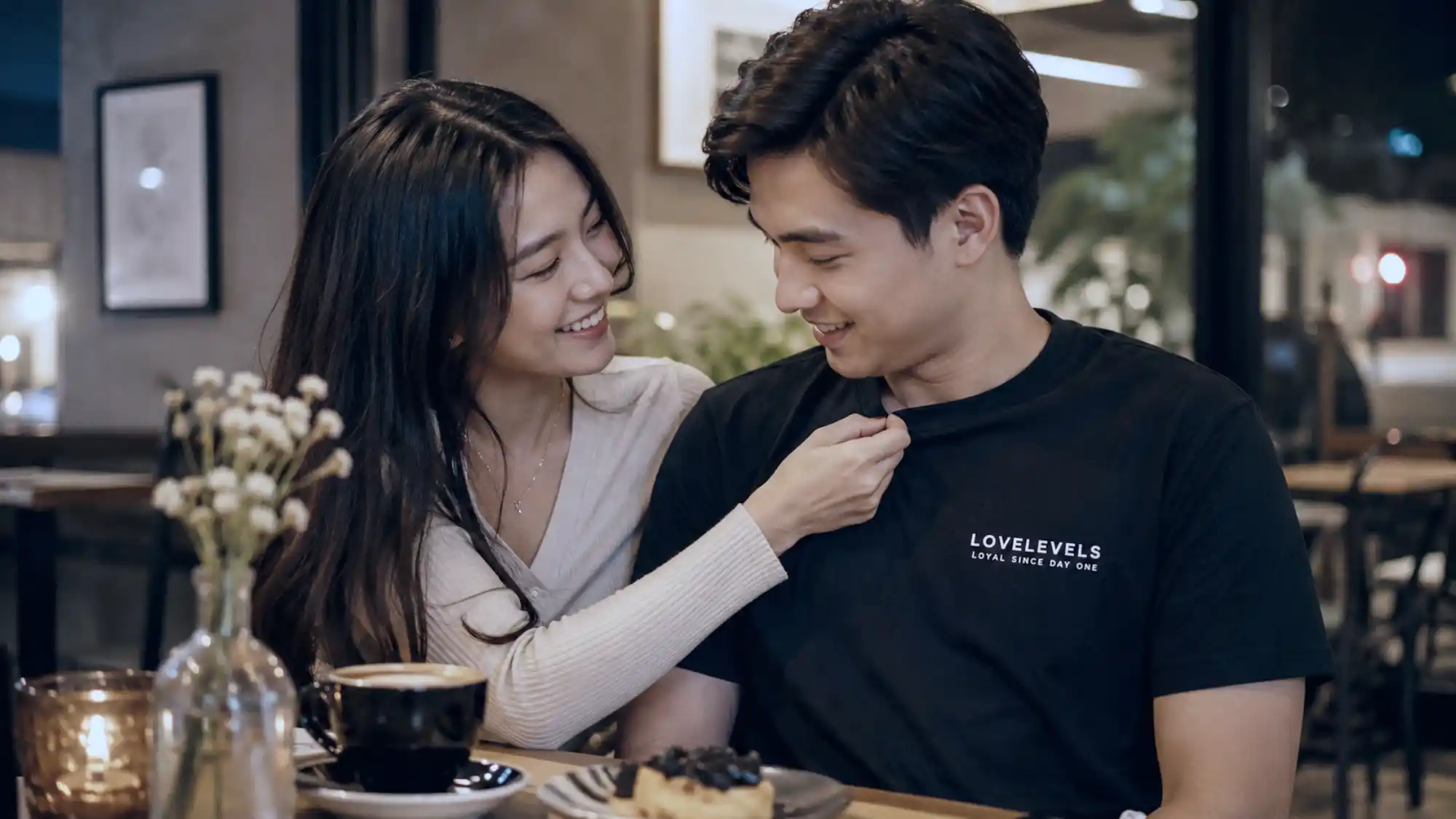Filipino couple wearing relationship statement shirts during a cozy cafe date_wp