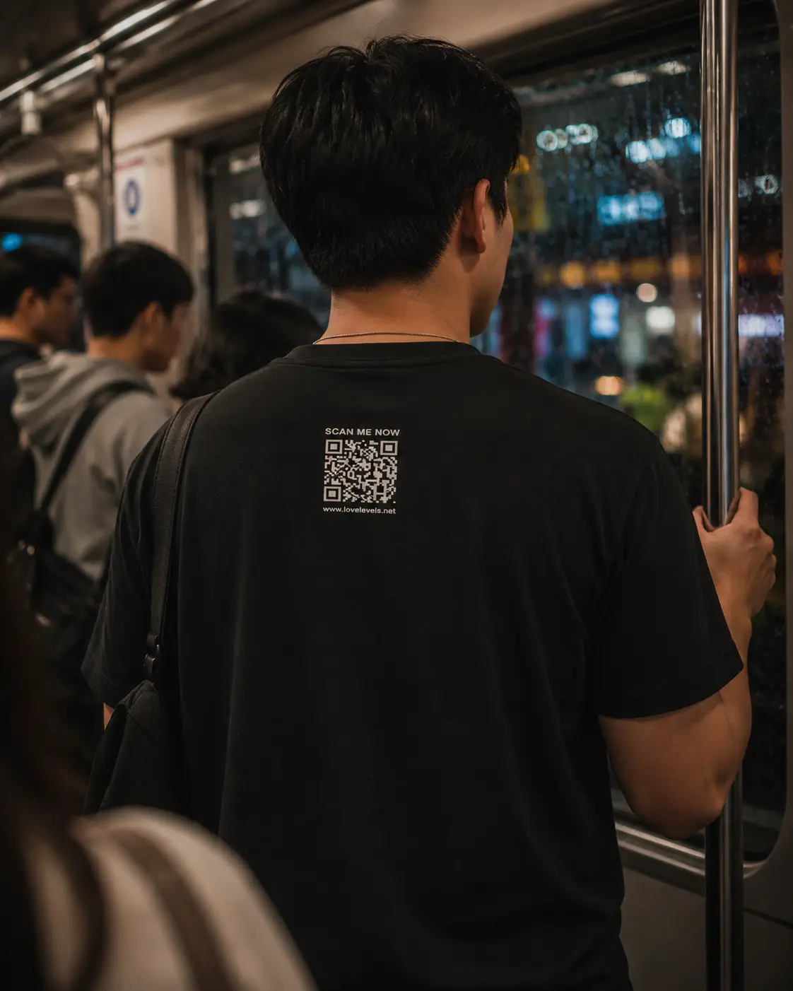 Filipino man wearing a LoveLevels QR shirt inside a rainy night train commute.